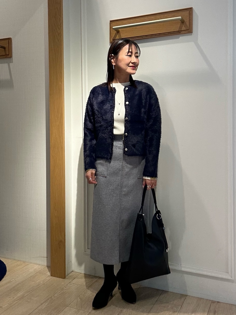 ベージュ系のムートンコート、ブルー系のニット/セーター、ホワイト系のニット/セーターを着用したレディースの冬コーディネートの8枚目の写真