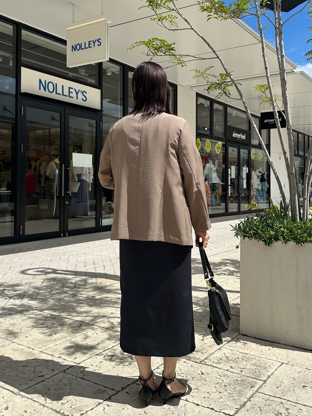 ブルー系のスカート、イエロー系のノーカラージャケット、ベージュ系のシャツ/ブラウスを着用したレディースの夏コーディネートの6枚目の写真