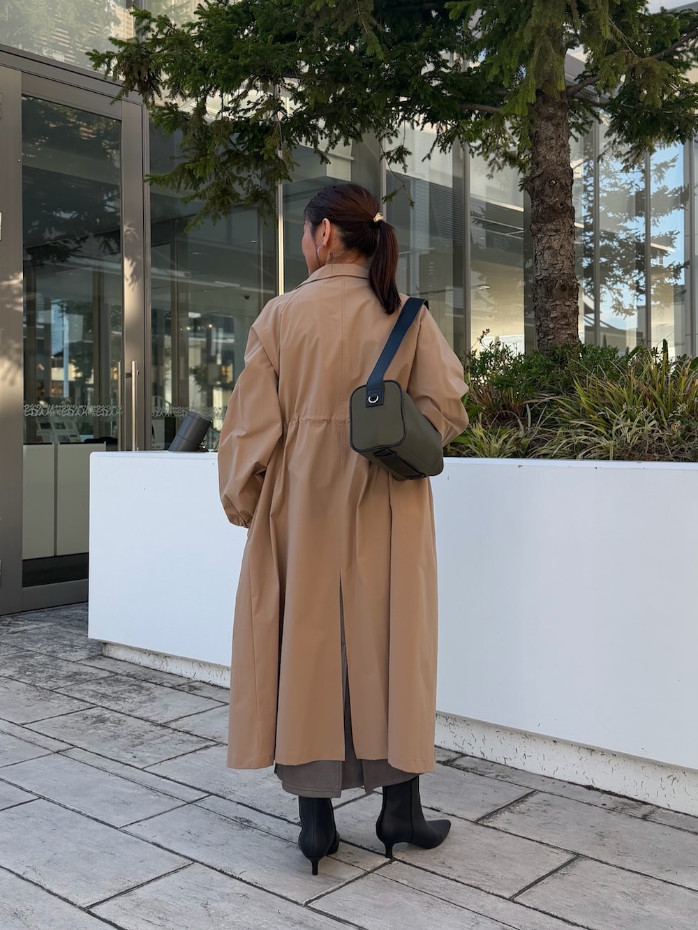グレー系のTシャツ/カットソー、イエロー系のダッフルコート、グレー系のスカートを着用したレディースの秋コーディネートの3枚目の写真