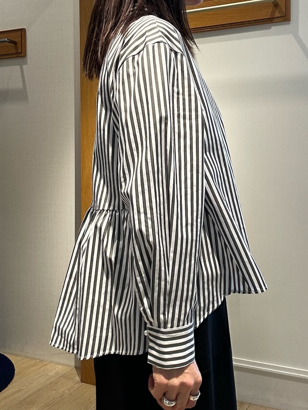 ブラック系のスカート、グレー系のシャツ/ブラウスを着用したレディースの春コーディネートの5枚目の写真