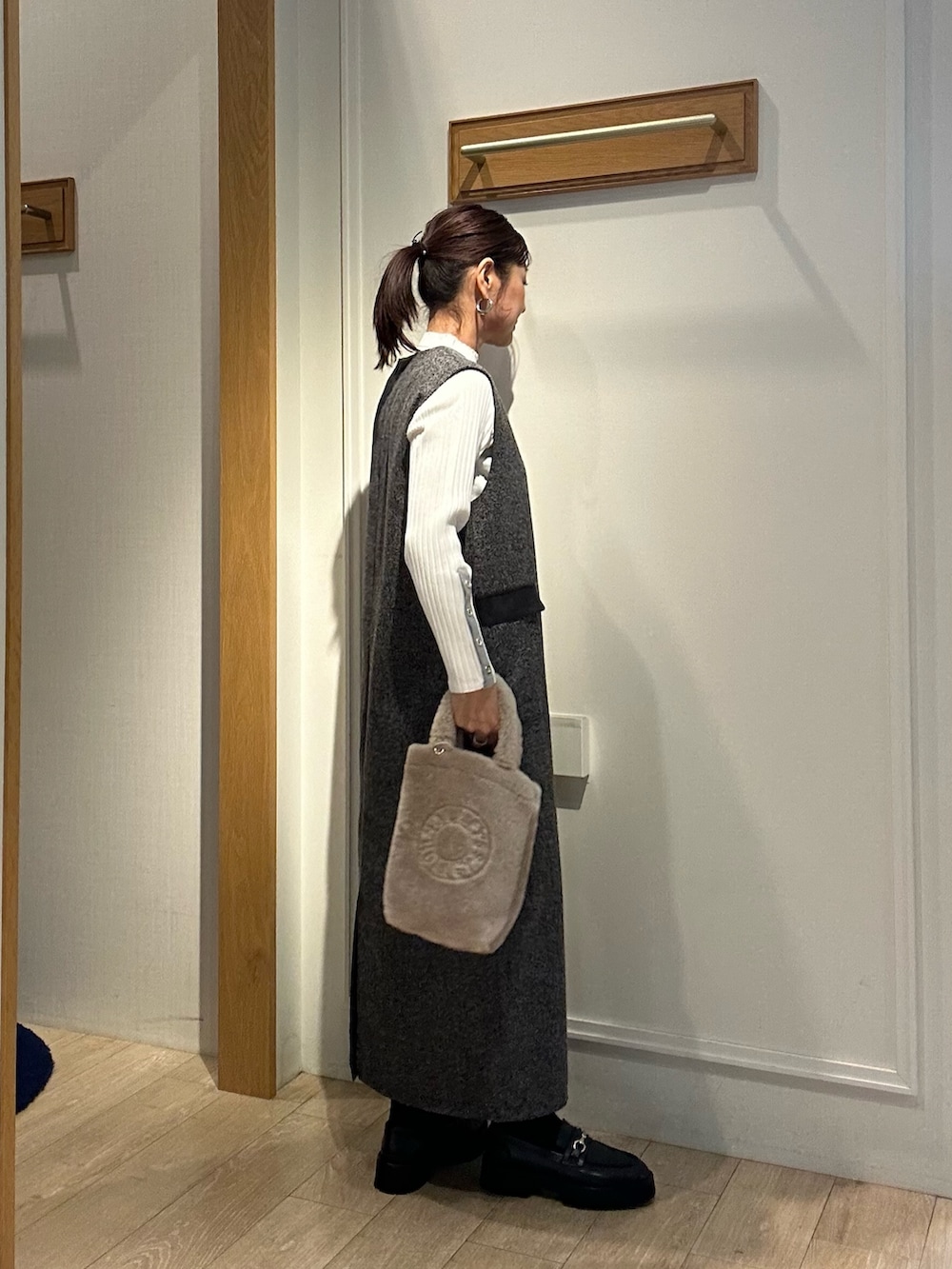 グレー系のワンピース、ホワイト系のニット/セーター、ベージュ系のトートバッグを着用したレディースの秋コーディネートの2枚目の写真