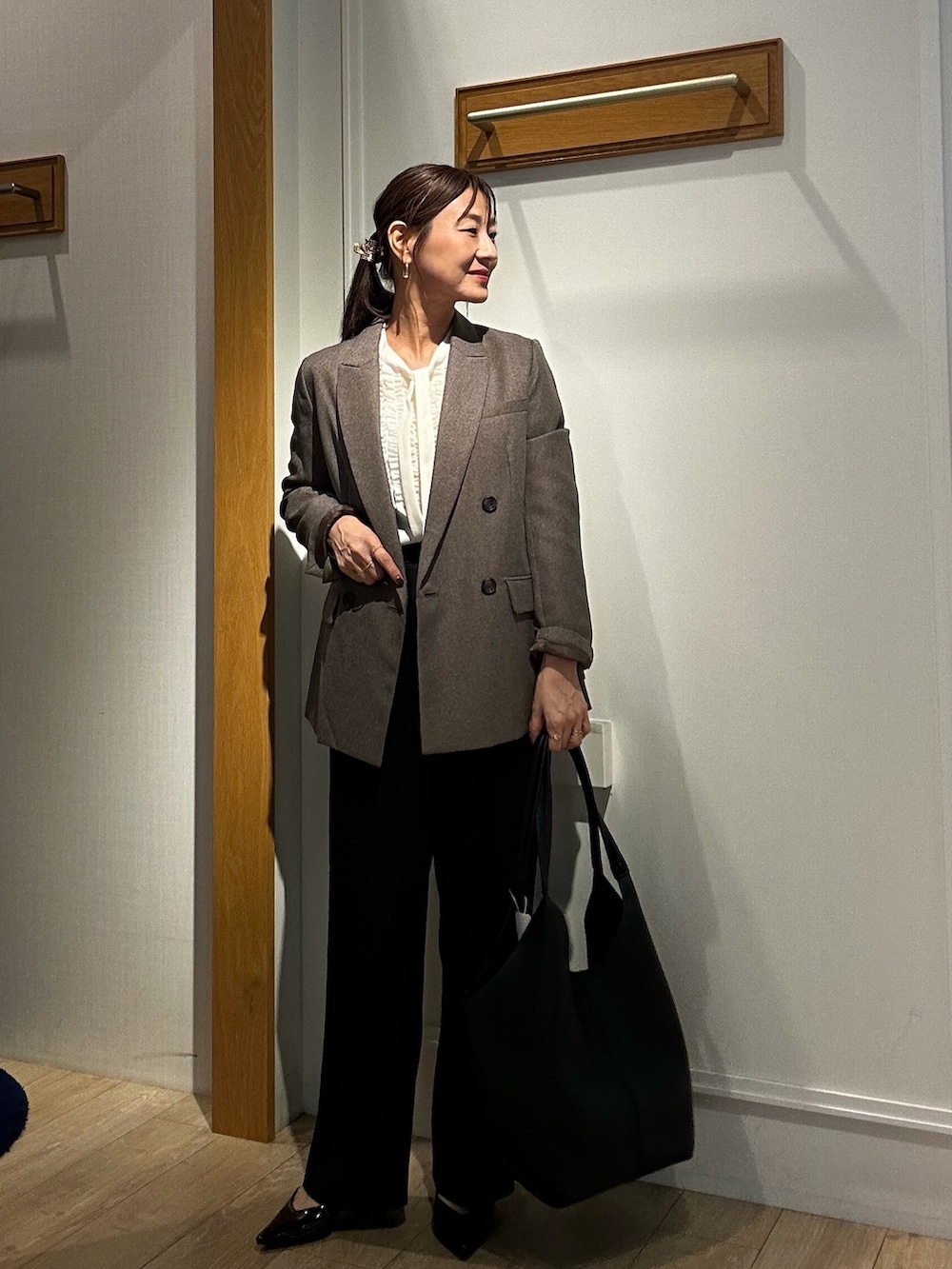ブラウン系のテーラードジャケット、ブラック系のその他パンツ、ホワイト系のシャツ/ブラウスを着用したレディースの秋コーディネートの5枚目の写真