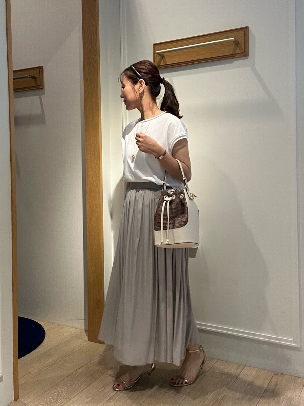 ホワイト系のTシャツ/カットソー、ベージュ系のスカート、ホワイト系のブルゾンを着用したレディースの春コーディネートの3枚目の写真