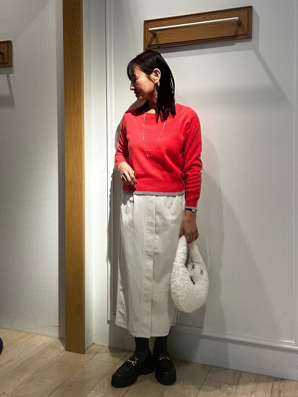 グレー系のダウンジャケット/コート、ピンク系のニット/セーター、ホワイト系のスカートを着用したレディースの冬コーディネートの9枚目の写真