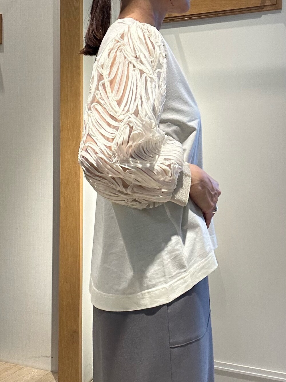 ホワイト系のTシャツ/カットソー、グレー系のスカート、イエロー系のショルダーバッグを着用したレディースの春コーディネートの6枚目の写真