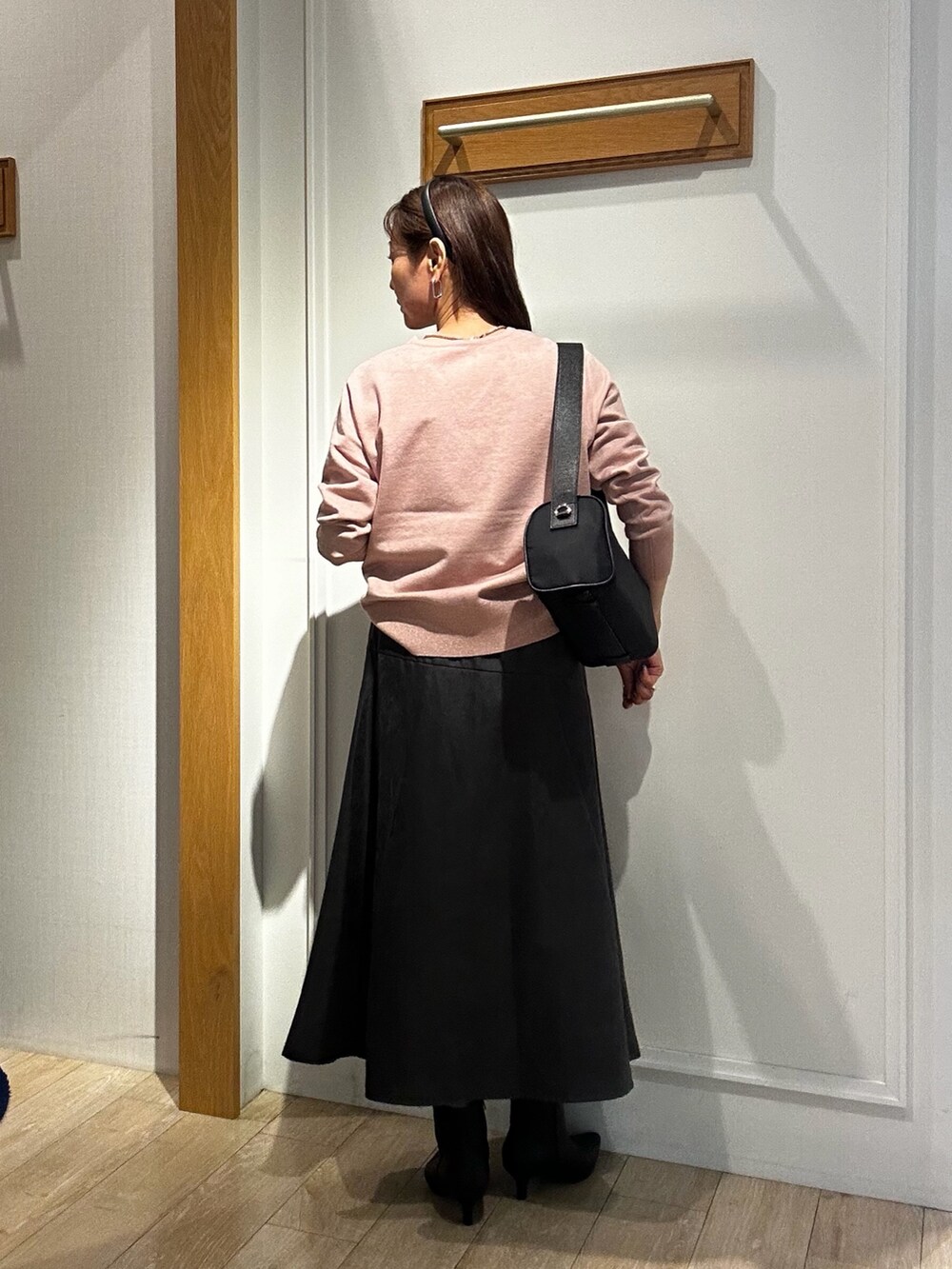 ピンク系のニット/セーター、グレー系のスカート、ブルー系のショルダーバッグを着用したレディースの秋コーディネートの3枚目の写真