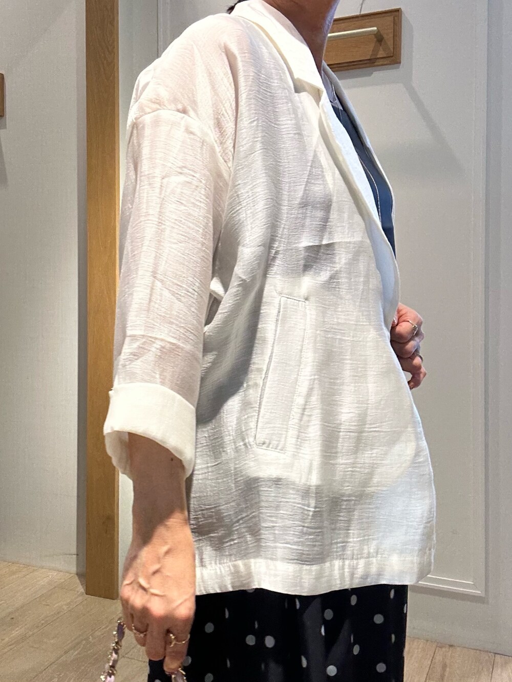 グレー系のTシャツ/カットソー、ホワイト系のテーラードジャケット、ブラック系のスカートを着用したレディースの春コーディネートの8枚目の写真