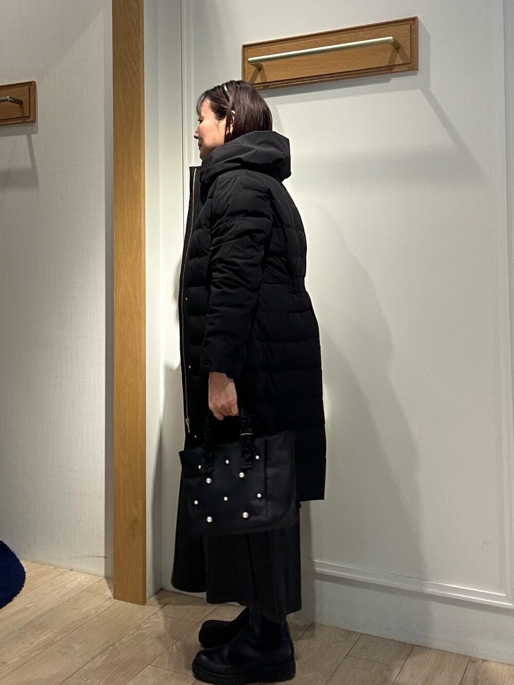 ブラック系のダウンジャケット/コート、ベージュ系のブルゾン、グレー系のワンピースを着用したレディースの冬コーディネートの2枚目の写真