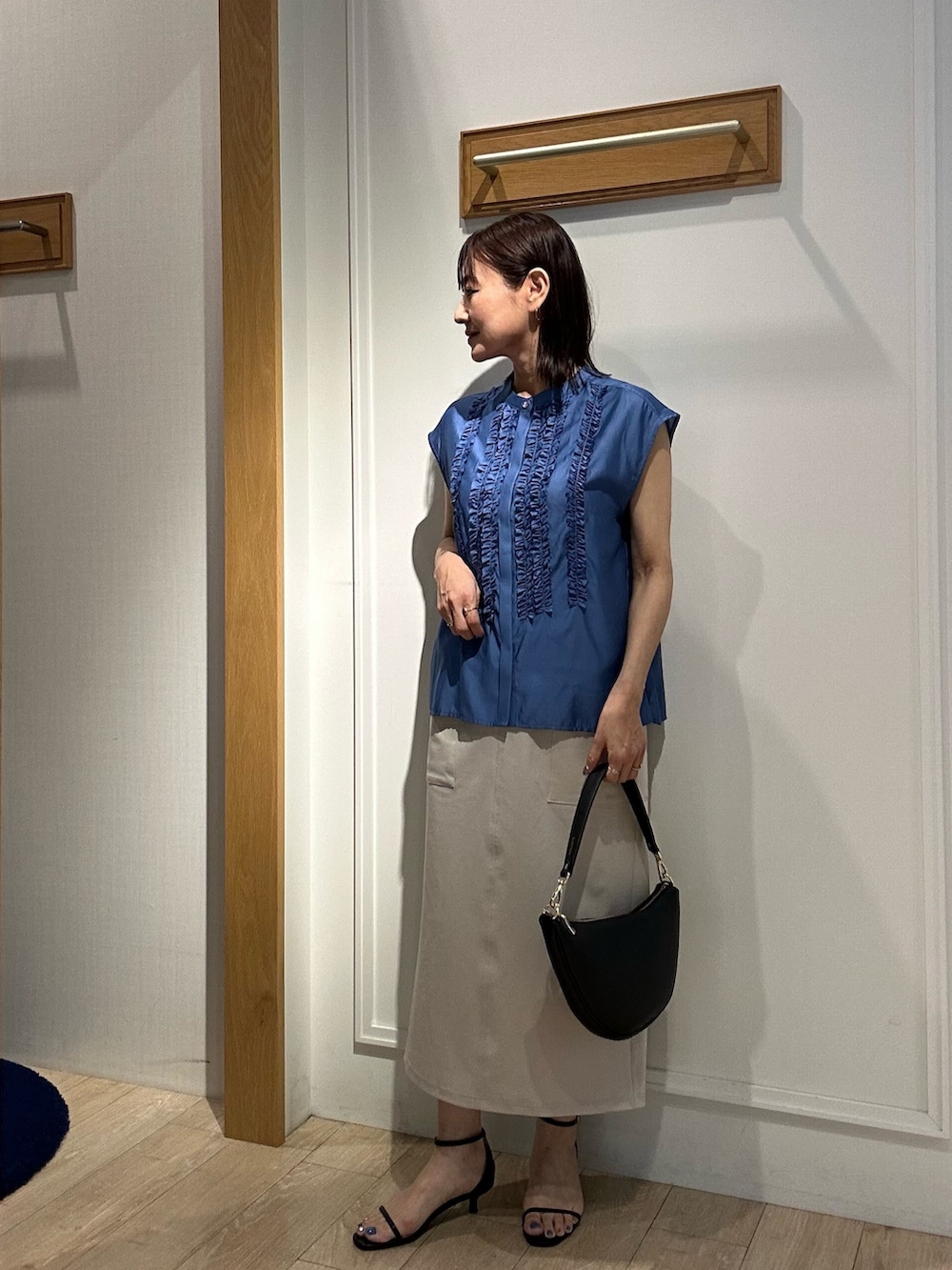 ブルー系のシャツ/ブラウス、ベージュ系のスカート、ブラック系のサンダルを着用したレディースの夏コーディネートの9枚目の写真