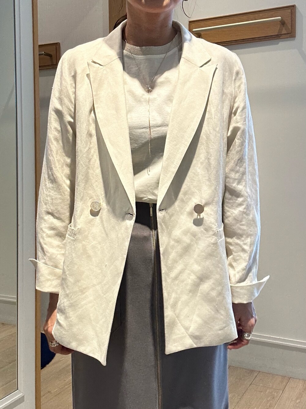 ホワイト系のテーラードジャケット、ホワイト系のTシャツ/カットソー、グレー系のスカートを着用したレディースの春コーディネートの4枚目の写真