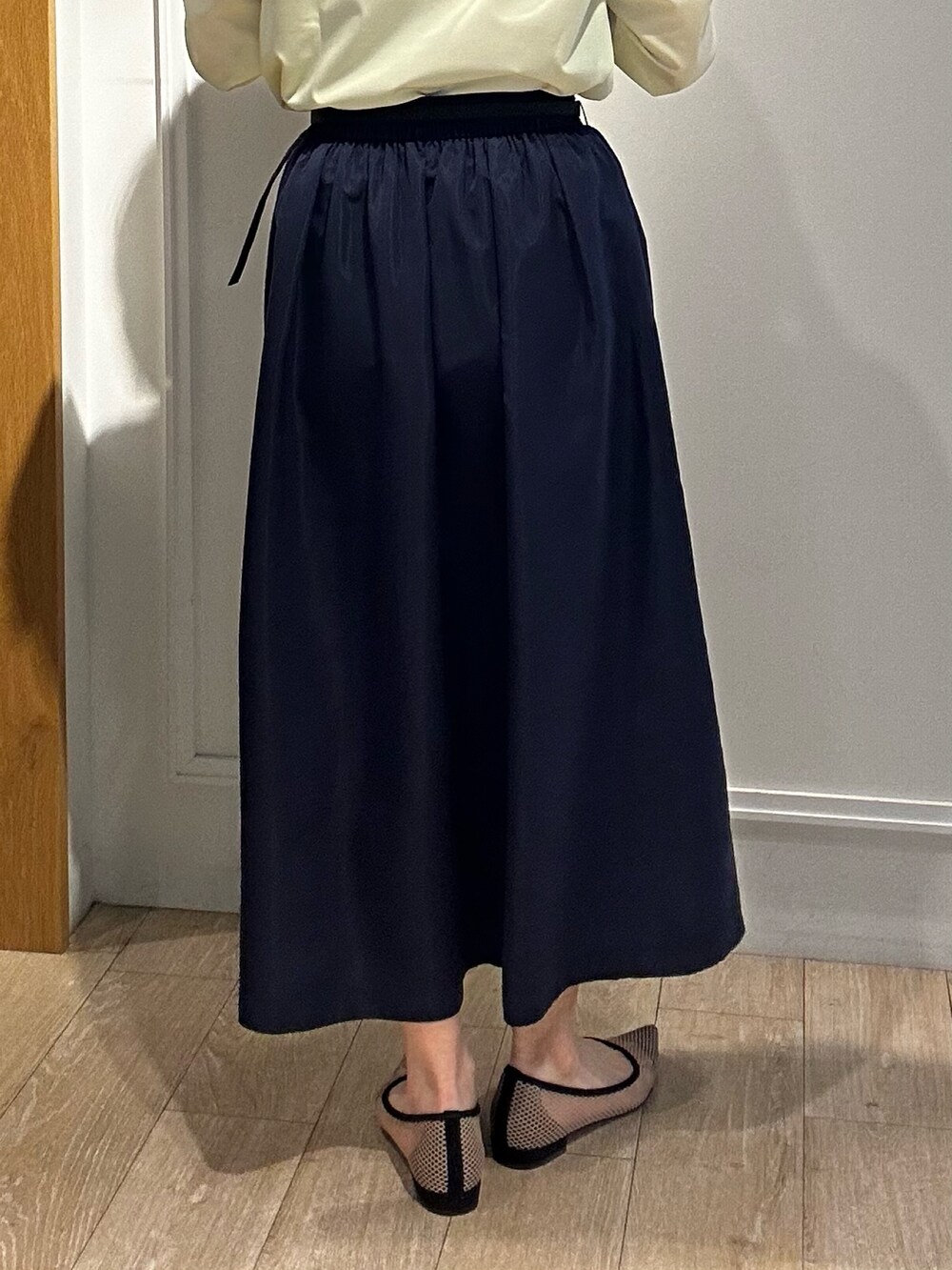 イエロー系のシャツ/ブラウス、ブルー系のスカート、ホワイト系のニット/セーターを着用したレディースの冬コーディネートの8枚目の写真