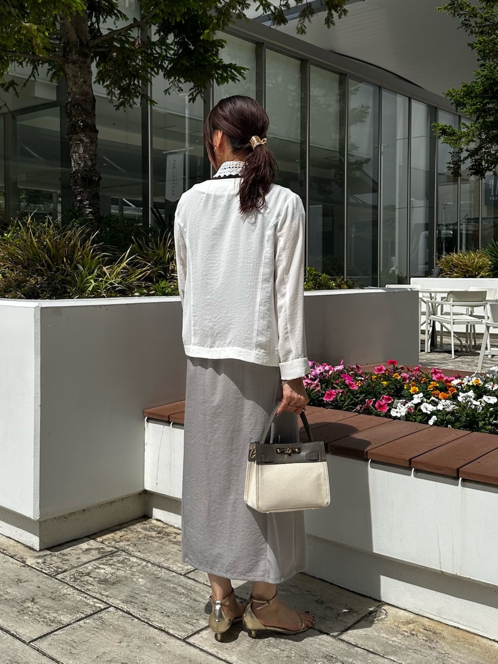 ホワイト系のノーカラージャケット、ブラウン系のTシャツ/カットソー、グレー系のスカートを着用したレディースの夏コーディネートの3枚目の写真