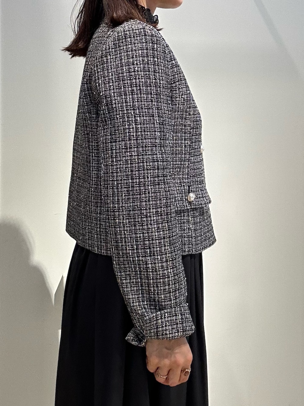 ブラック系のノーカラージャケット、ブラック系のTシャツ/カットソー、ブルー系のスカートを着用したレディースの冬コーディネートの6枚目の写真