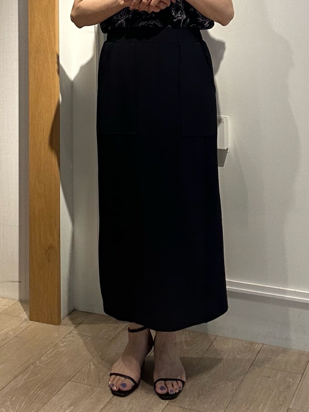 ブラック系のシャツ/ブラウス、ブラック系のスカート、ベージュ系のノーカラージャケットを着用したレディースの夏コーディネートの7枚目の写真