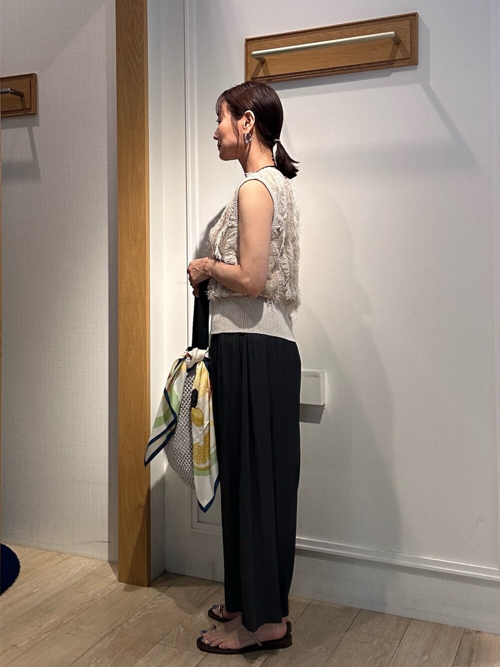 ベージュ系のニット/セーター、グレー系のその他パンツ、グレー系のショルダーバッグを着用したレディースの夏コーディネートの2枚目の写真