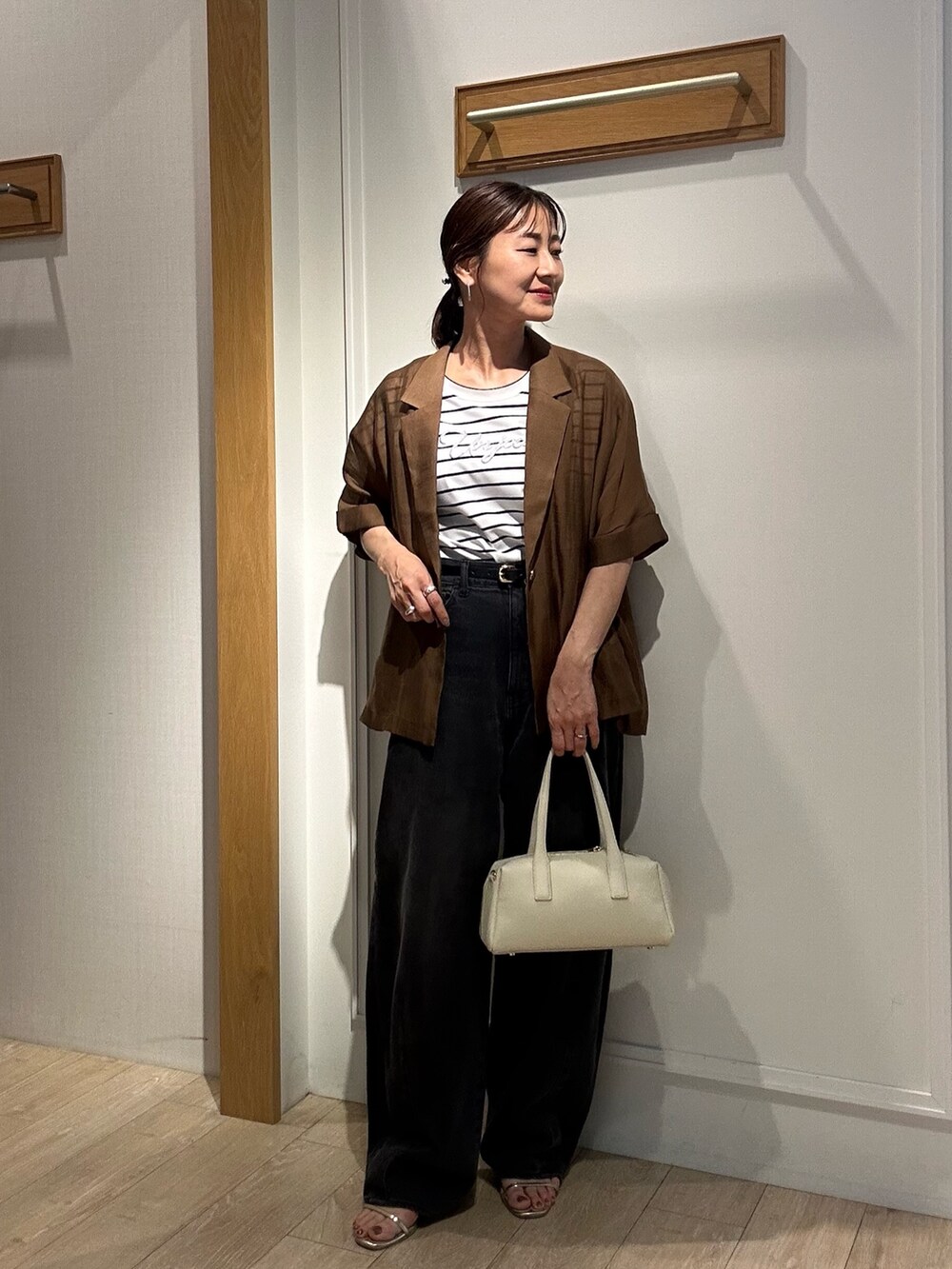 ホワイト系のTシャツ/カットソー、ホワイト系のボストンバッグ、ブラウン系のテーラードジャケットを着用したレディースの夏コーディネートの6枚目の写真