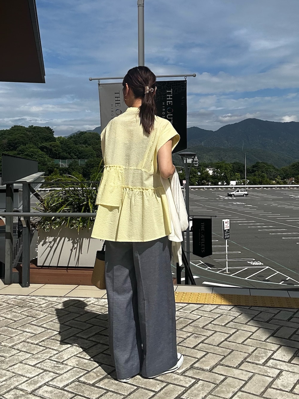 イエロー系のシャツ/ブラウス、ブルー系のその他パンツ、ブルー系のカーディガン/ボレロを着用したレディースの春コーディネートの2枚目の写真