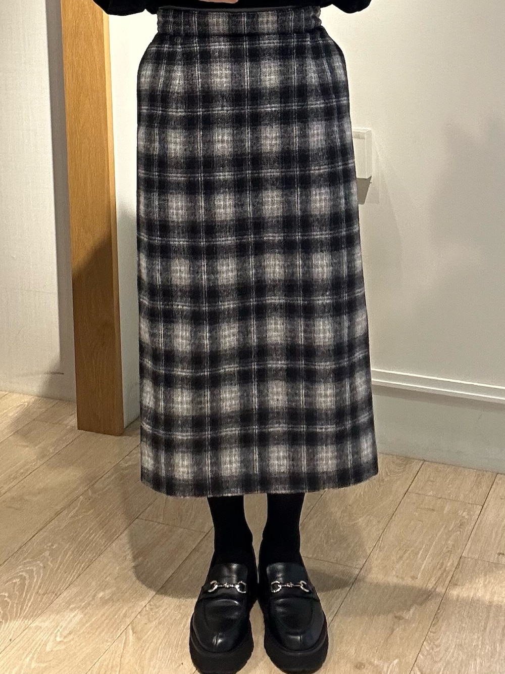 ホワイト系のトートバッグ、ホワイト系のテーラードジャケット、ブラック系のニット/セーターを着用したレディースの冬コーディネートの7枚目の写真