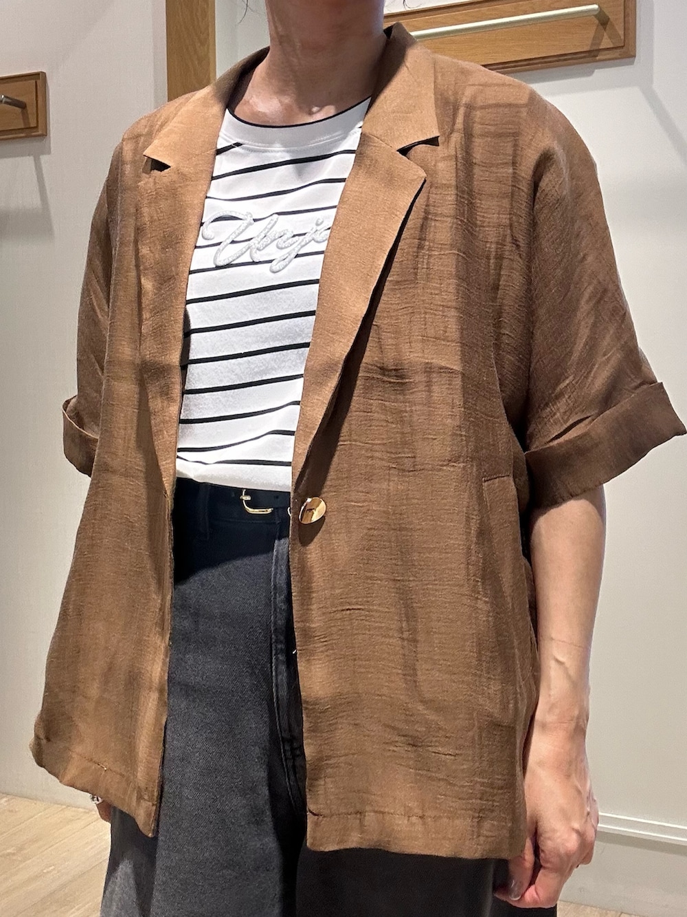 ホワイト系のTシャツ/カットソー、ホワイト系のボストンバッグ、ブラウン系のテーラードジャケットを着用したレディースの夏コーディネートの7枚目の写真