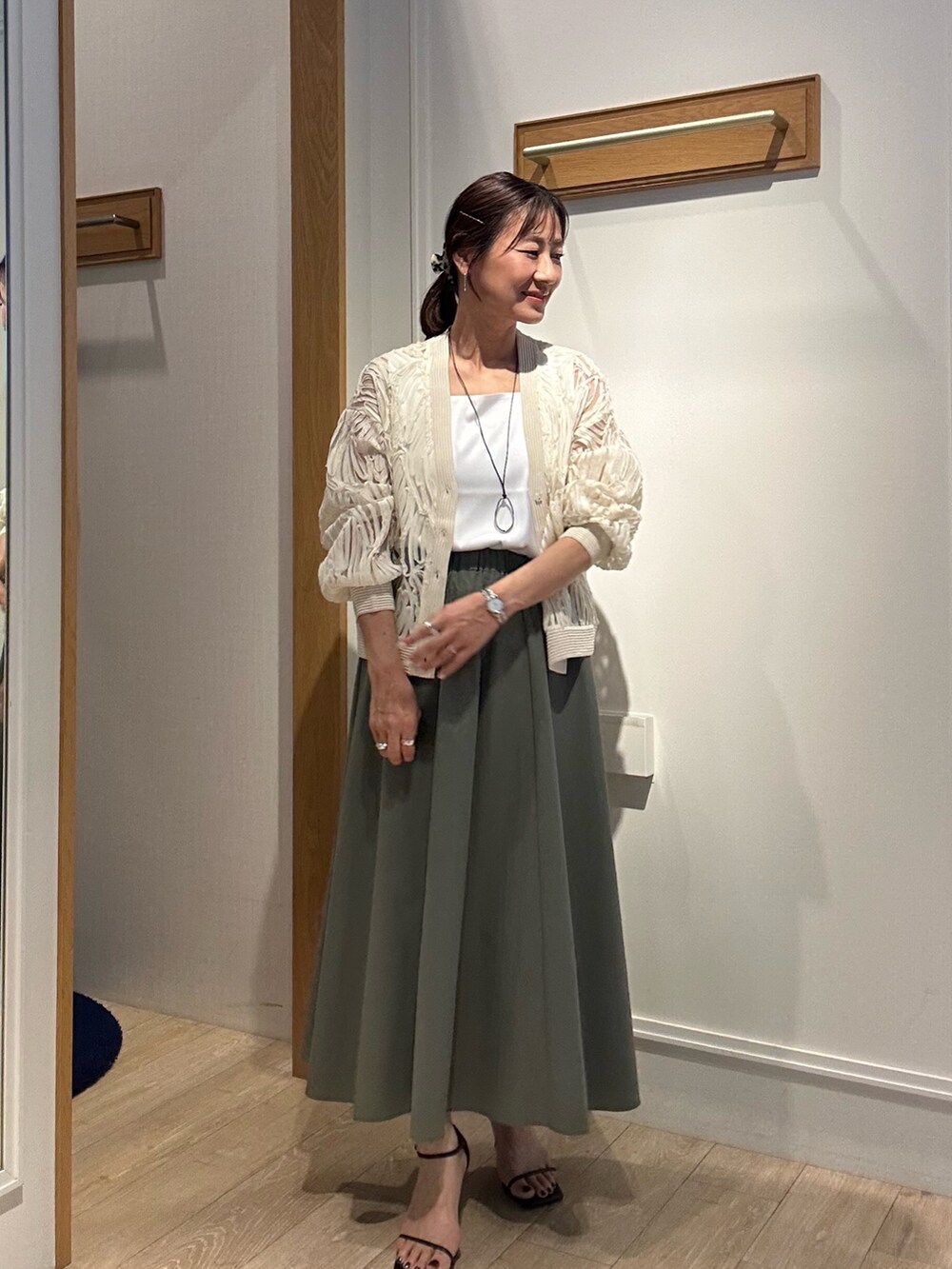 ホワイト系のカーディガン/ボレロ、シルバー系のネックレスを着用したレディースの冬コーディネートの6枚目の写真