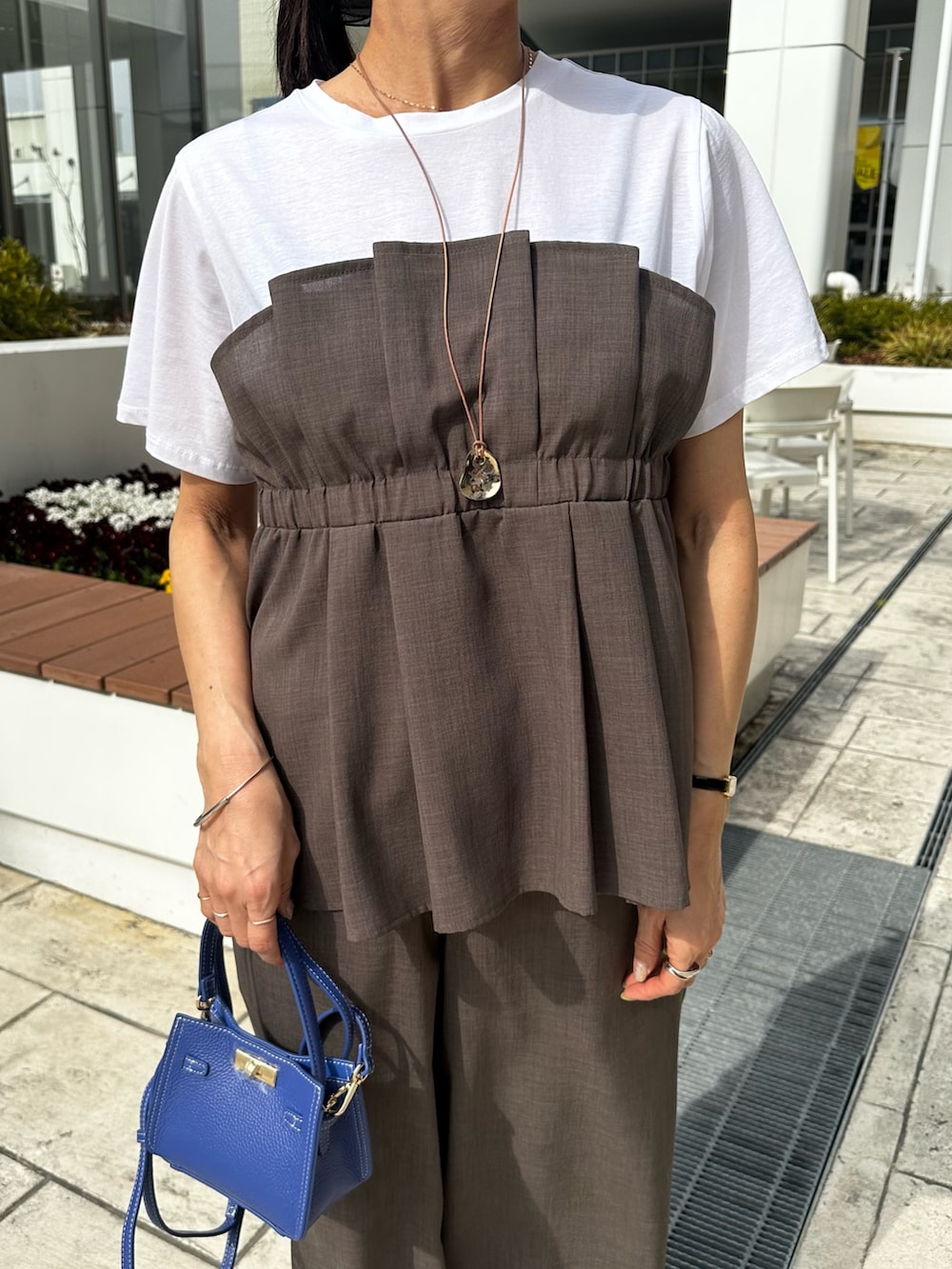 グリーン系のシャツ/ブラウス、ブルー系のブルゾン、ブルー系のショルダーバッグを着用したレディースの春コーディネートの4枚目の写真