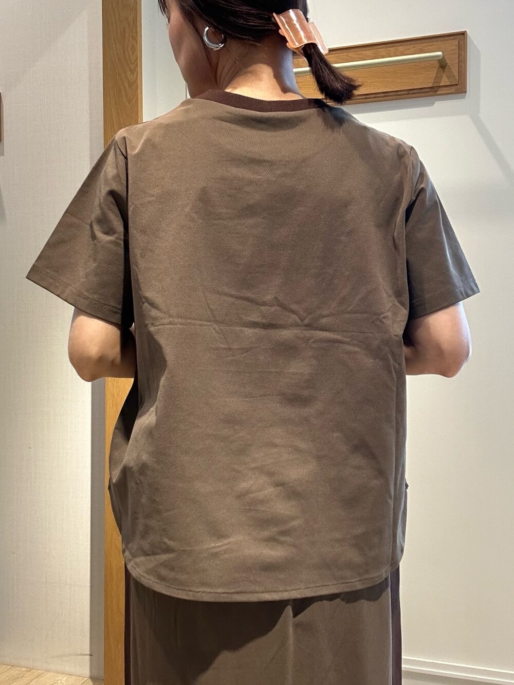 ブラウン系のTシャツ/カットソー、ブラウン系のスカート、ブラック系のサンダルを着用したレディースの夏コーディネートの7枚目の写真