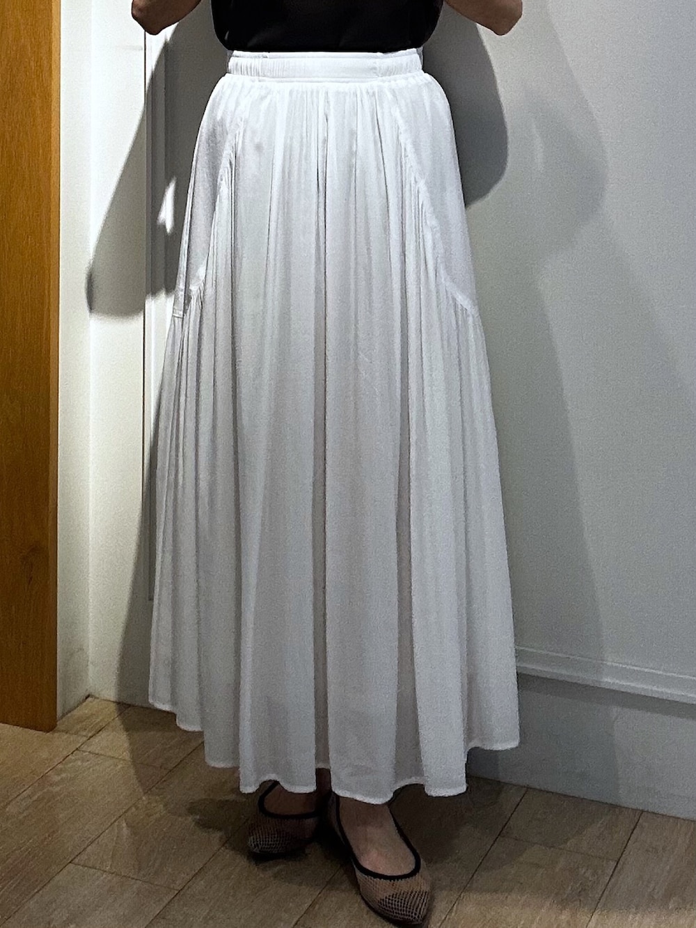 イエロー系のブルゾン、ブラウン系のTシャツ/カットソー、ホワイト系のスカートを着用したレディースの春コーディネートの7枚目の写真