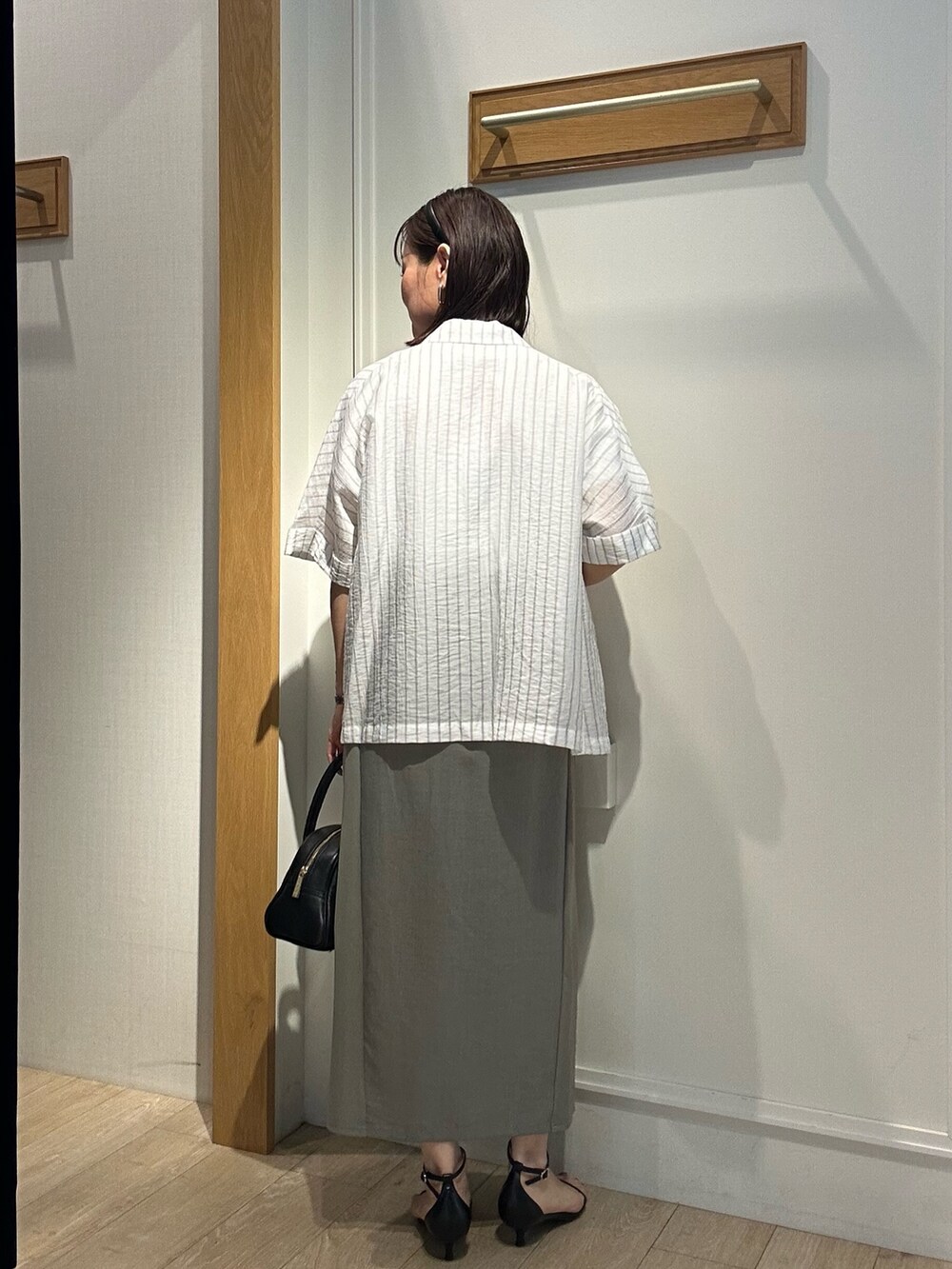 グレー系のテーラードジャケット、ホワイト系のTシャツ/カットソー、グリーン系のスカートを着用したレディースの夏コーディネートの3枚目の写真