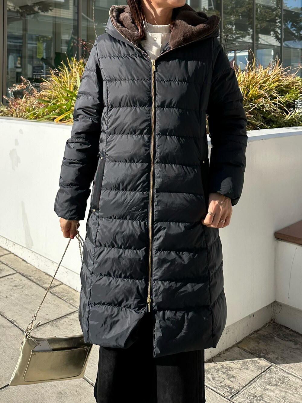 ブラック系のダウンジャケット/コート、ゴールド系のショルダーバッグを着用したレディースの冬コーディネートの3枚目の写真