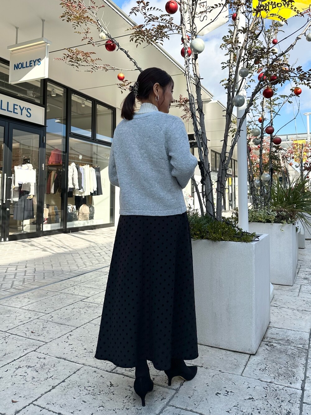 グレー系のニット/セーター、ブラック系のショルダーバッグを着用したレディースの冬コーディネートの4枚目の写真