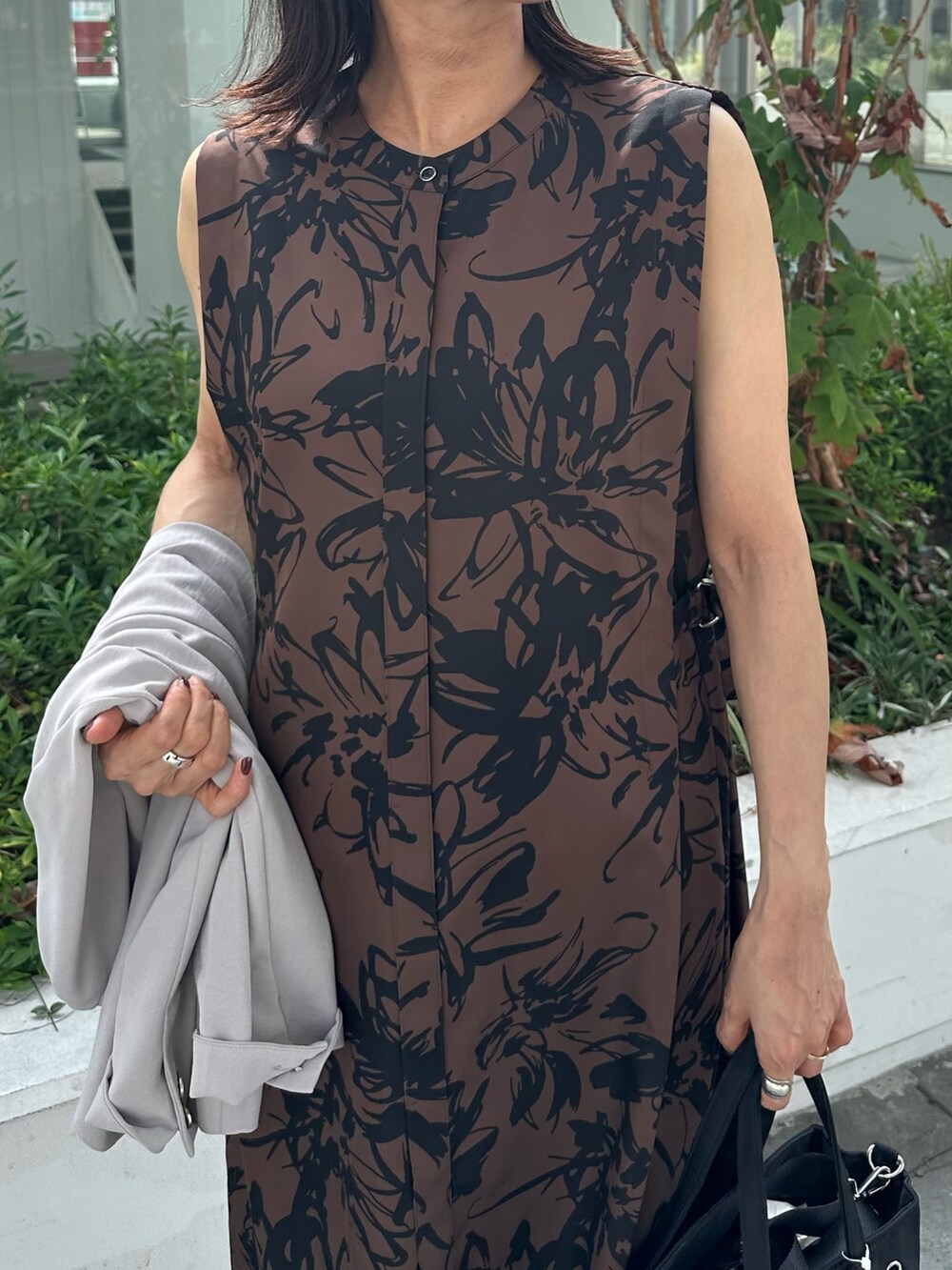 ベージュ系のワンピース、ブラック系のトートバッグ、ベージュ系のノーカラージャケットを着用したレディースの秋コーディネートの4枚目の写真