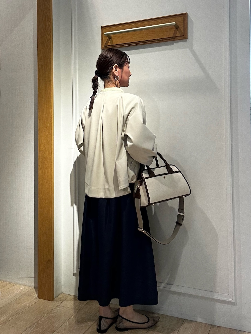 イエロー系のシャツ/ブラウス、ホワイト系のブルゾン、ブルー系のスカートを着用したレディースの冬コーディネートの2枚目の写真