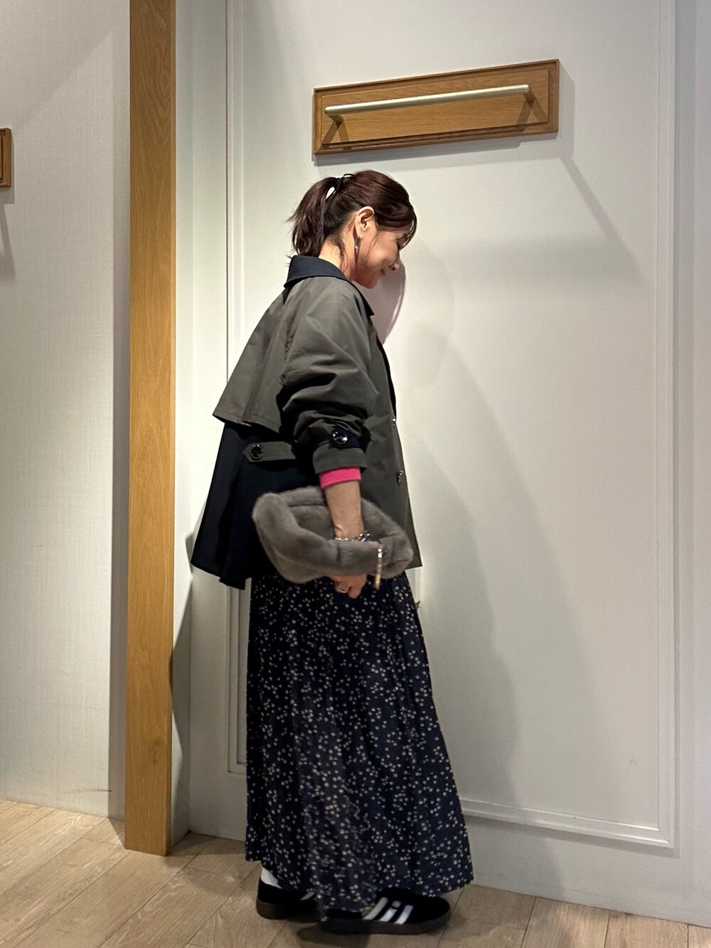 グレー系のトレンチコート、ピンク系のニット/セーターを着用したレディースの秋コーディネートの2枚目の写真