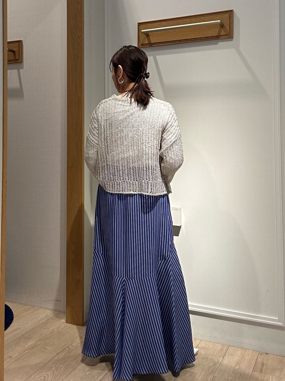 ベージュ系のニット/セーター、ホワイト系のTシャツ/カットソー、ゴールド系のショルダーバッグを着用したレディースの冬コーディネートの2枚目の写真