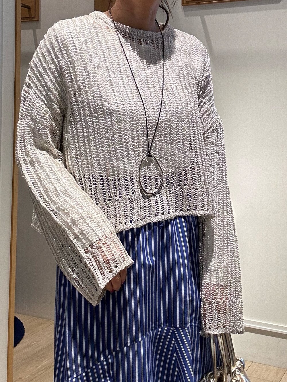 ベージュ系のニット/セーター、ホワイト系のTシャツ/カットソー、ゴールド系のショルダーバッグを着用したレディースの冬コーディネートの5枚目の写真