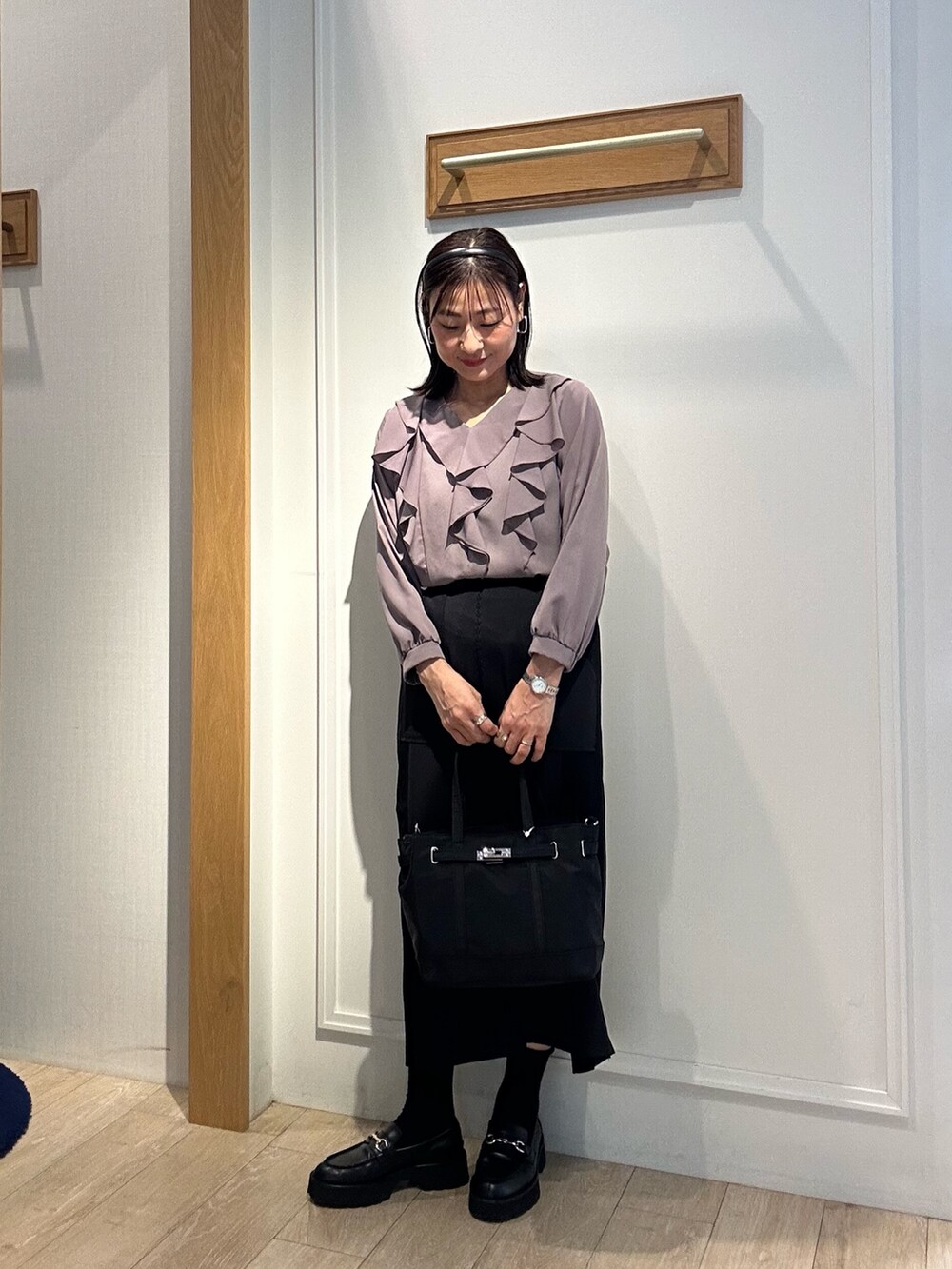 ブラウン系のシャツ/ブラウス、ブラック系のスカート、ブラック系のトートバッグを着用したレディースの秋コーディネートの5枚目の写真