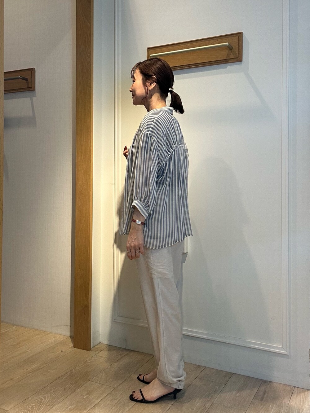 ブルー系のシャツ/ブラウス、ベージュ系のその他パンツ、ブラック系のハットを着用したレディースの春コーディネートの4枚目の写真