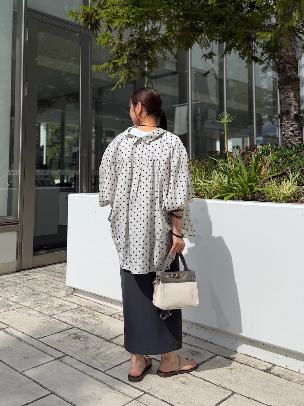 ホワイト系のTシャツ/カットソー、グレー系のスカート、ベージュ系のショルダーバッグを着用したレディースの夏コーディネートの3枚目の写真
