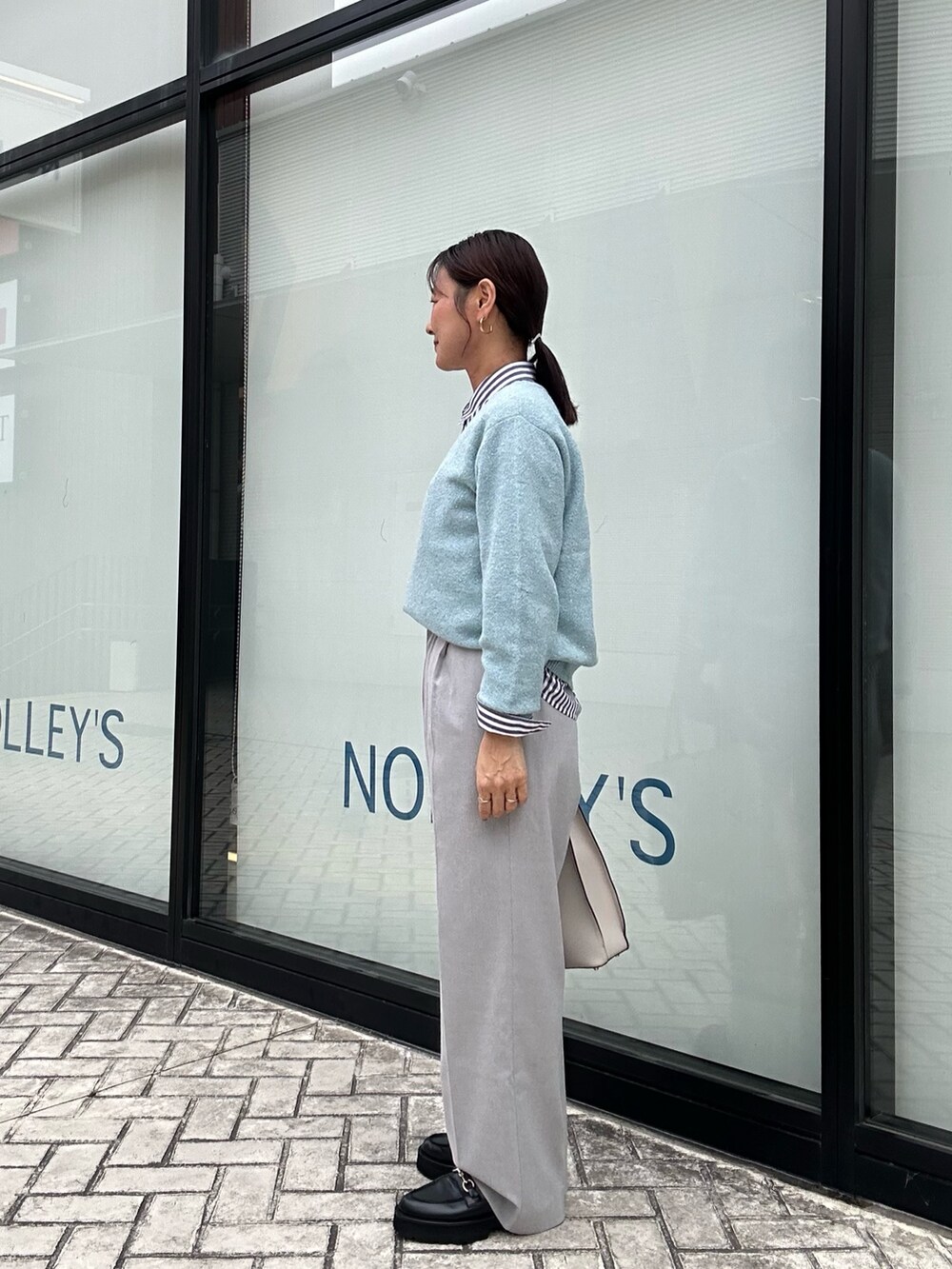ブルー系のニット/セーター、グレー系のその他パンツ、ブラック系のシャツ/ブラウスを着用したレディースの秋コーディネートの2枚目の写真
