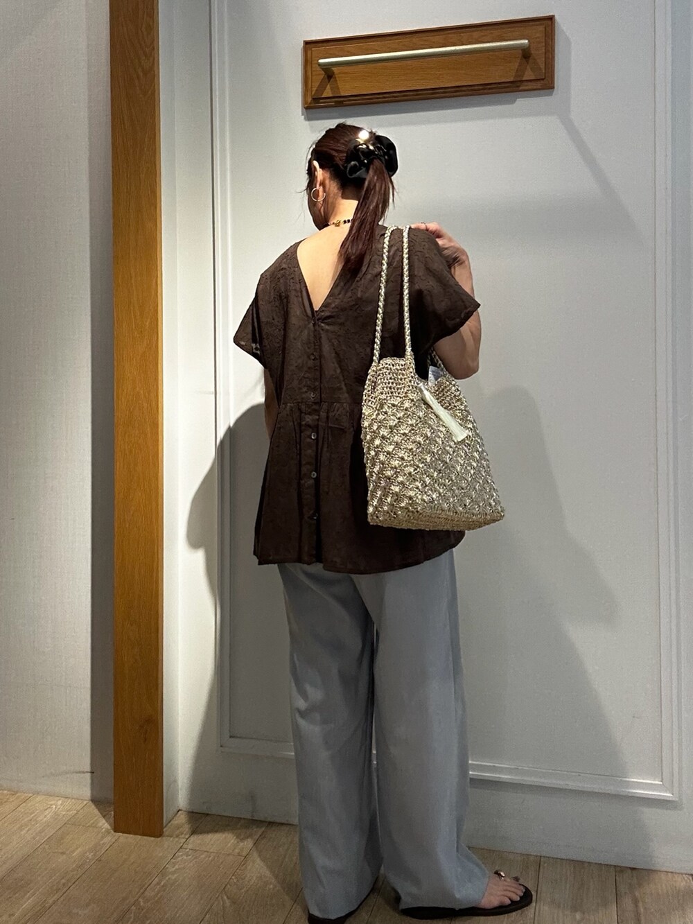 ブラウン系のシャツ/ブラウス、グレー系のその他パンツ、ゴールド系のトートバッグを着用したレディースの夏コーディネートの4枚目の写真