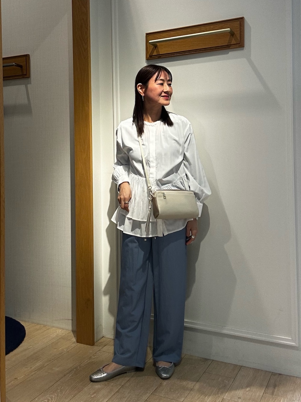 グリーン系のブルゾン、ホワイト系のシャツ/ブラウス、ブルー系のデニムパンツを着用したレディースの冬コーディネートの6枚目の写真