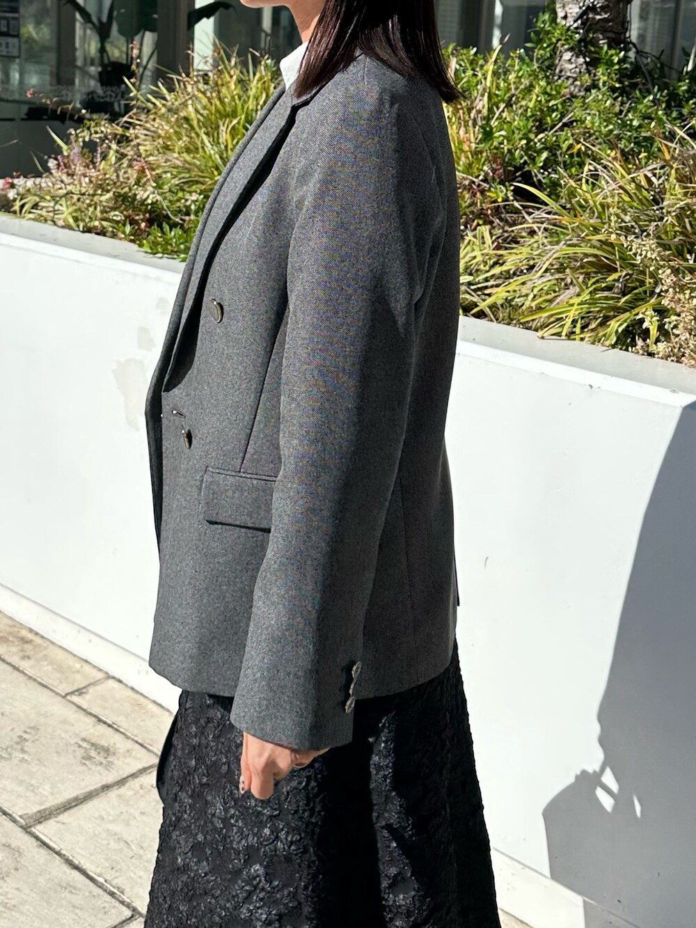 グレー系のテーラードジャケット、ブラック系のニット/セーター、グレー系のスカートを着用したレディースの秋コーディネートの6枚目の写真