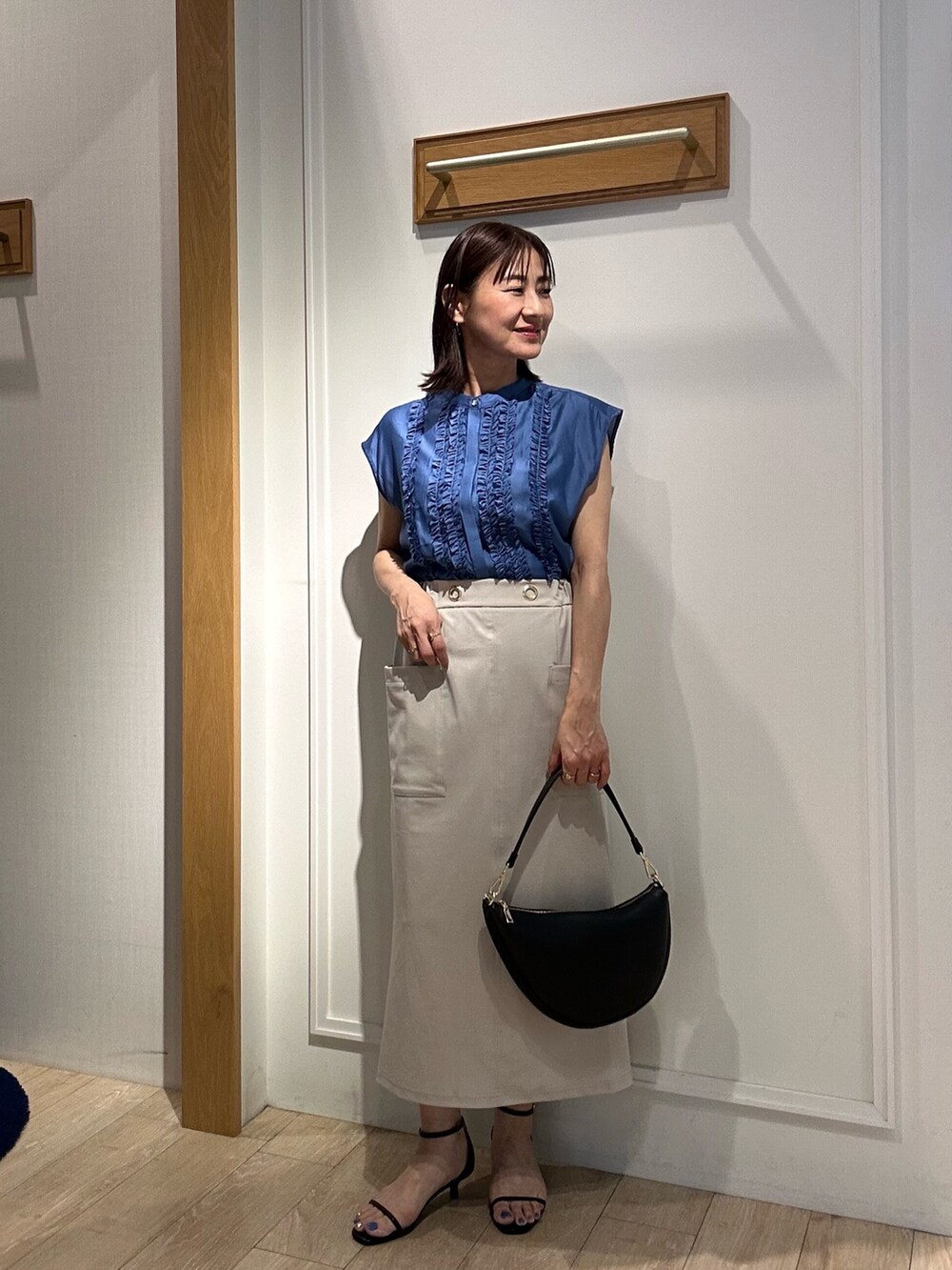 ブルー系のシャツ/ブラウス、ベージュ系のスカート、ブラック系のサンダルを着用したレディースの夏コーディネートの5枚目の写真