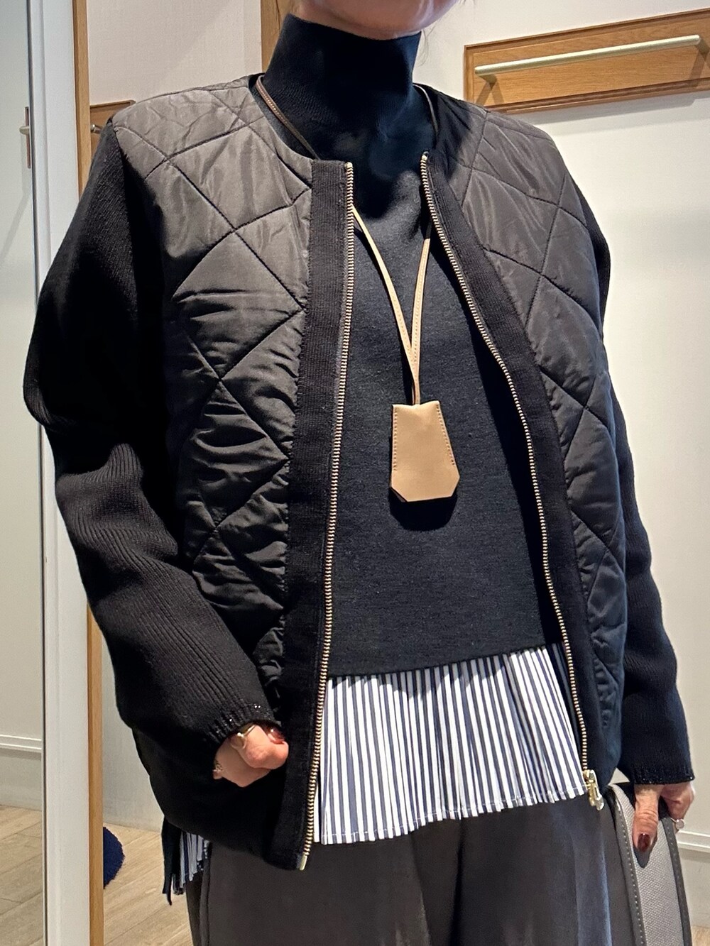 ブラック系のブルゾン、ブラック系のニット/セーター、グレー系のその他パンツを着用したレディースの秋コーディネートの5枚目の写真