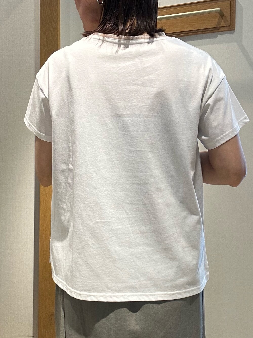 グリーン系のスカート、ホワイト系のTシャツ/カットソー、ブラック系のボストンバッグを着用したレディースの夏コーディネートの5枚目の写真