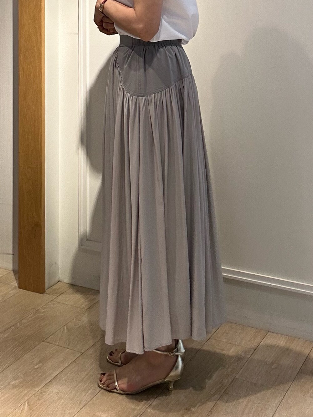 ベージュ系のスカート、ホワイト系のブルゾン、ホワイト系のTシャツ/カットソーを着用したレディースの春コーディネートの9枚目の写真