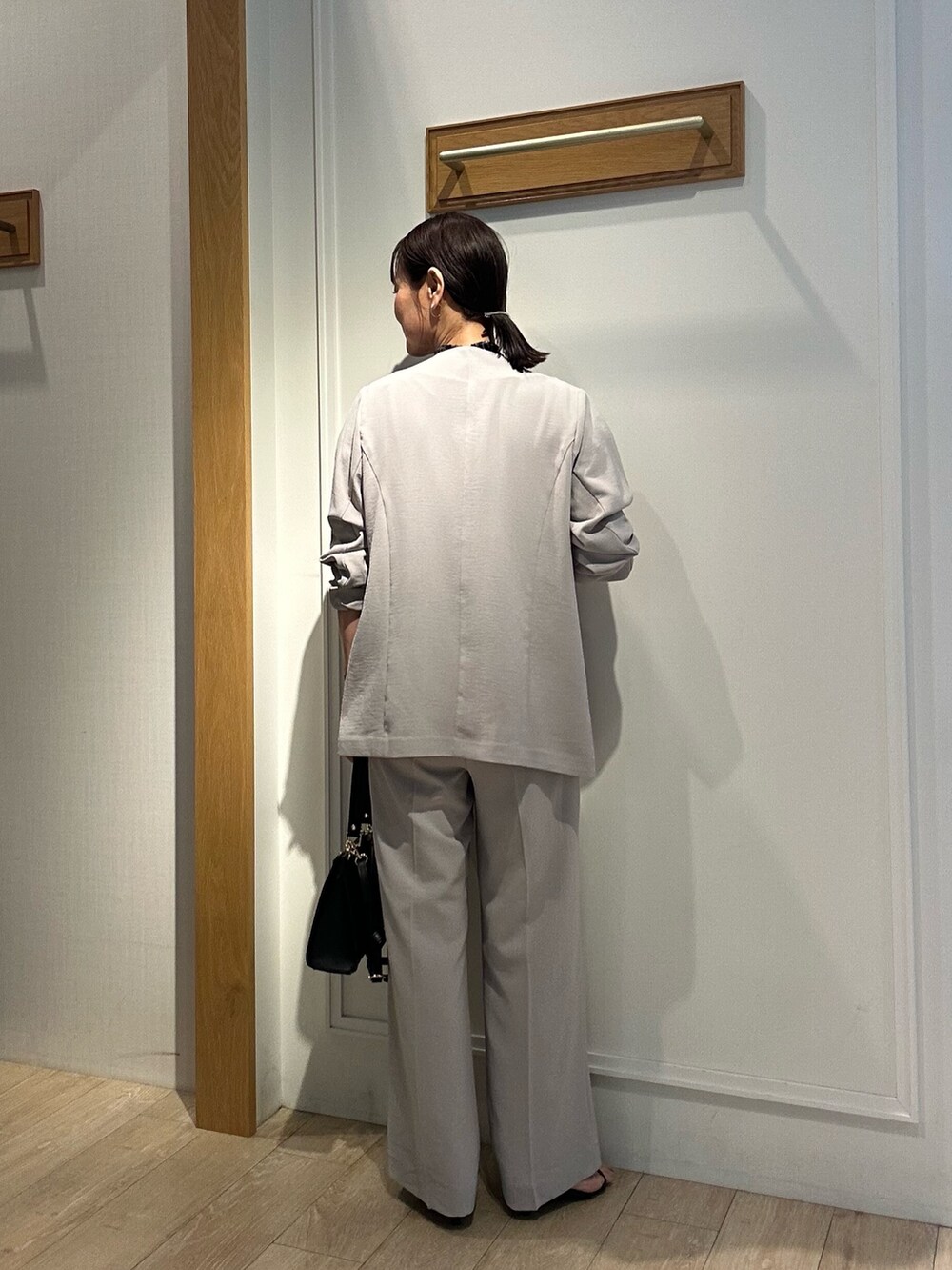 ベージュ系のノーカラージャケット、ベージュ系のその他パンツ、ブラック系のショルダーバッグを着用したレディースの夏コーディネートの3枚目の写真