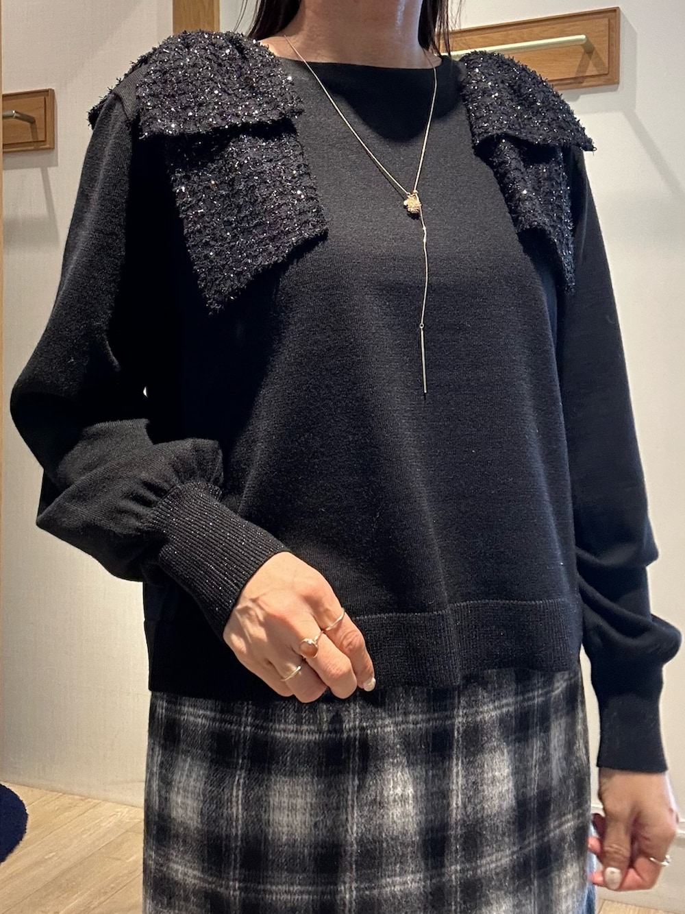 ブラック系のニット/セーター、ブルー系のスカート、ホワイト系のトートバッグを着用したレディースの冬コーディネートの5枚目の写真