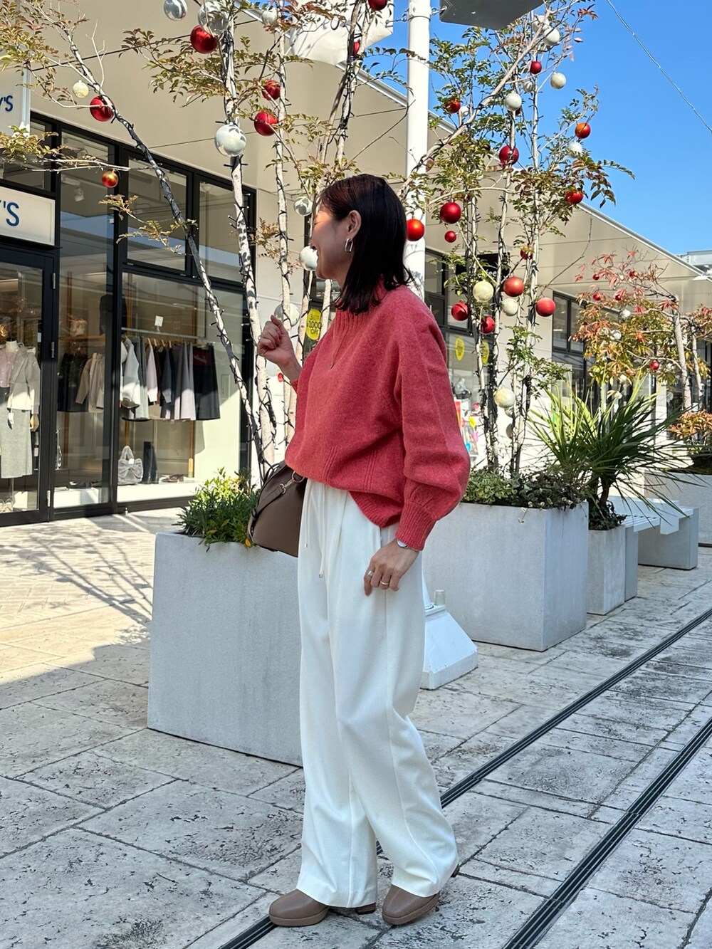 ブラウン系のブルゾン、オレンジ系のニット/セーターを着用したレディースの冬コーディネートの9枚目の写真