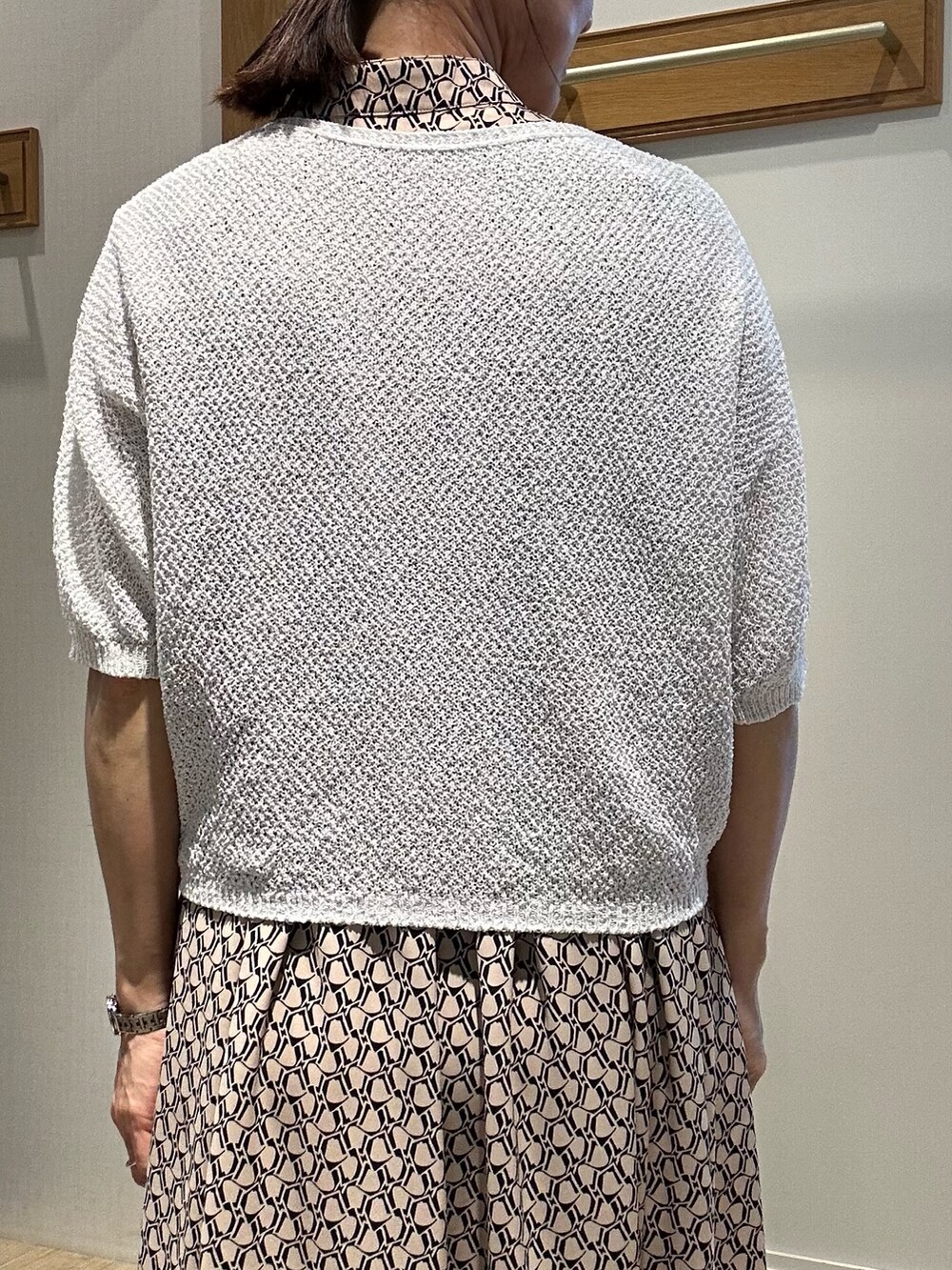 ベージュ系のワンピース、ホワイト系のカーディガン/ボレロ、ゴールド系のショルダーバッグを着用したレディースの春コーディネートの9枚目の写真